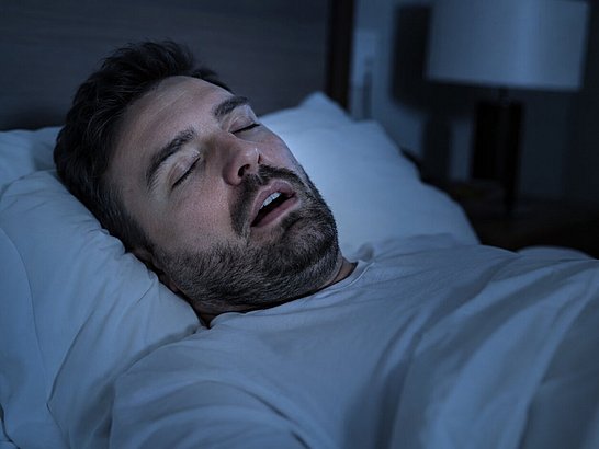 Persona acostada en la cama durante la noche con expresión de congestión nasal, respirando por la boca Persona acostada en la cama durante la noche con expresión de congestión nasal, respirando por la boca