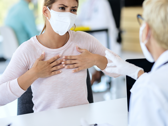 Mujer en consulta médica, recibiendo un diagnóstico de alergias respiratorias