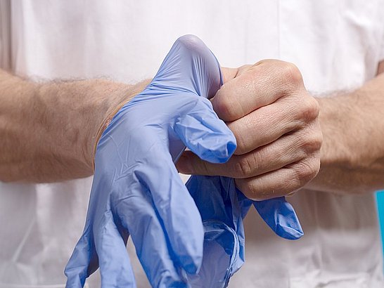 Médico con las manos irritadas por el uso prolongado de guantes de látex