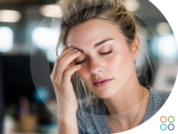 Persona en un entorno de oficina con expresión de cansancio leve mientras se toca los ojos Persona en un entorno de oficina con expresión de cansancio leve mientras se toca los ojos